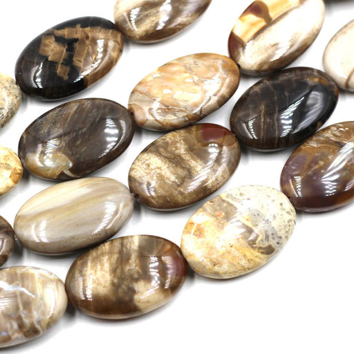 A collection of flat oval peanut wood jasper beads of various shades and patterns.