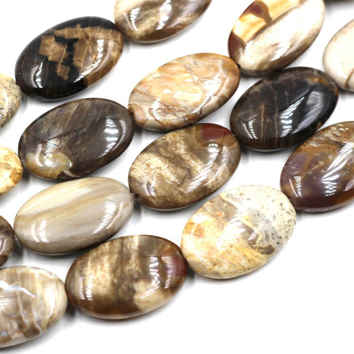 A collection of flat oval peanut wood jasper beads of various shades and patterns.
