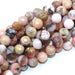 A string of faceted round pink Peruvian opal beads.