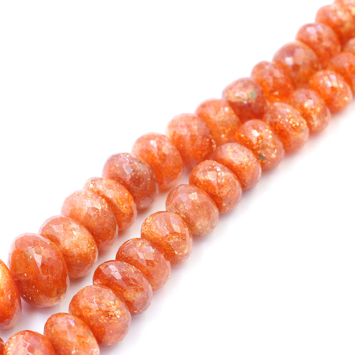A series of orange-colored sunstone beads of varying sizes strung together.